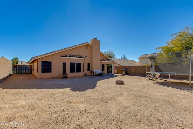 rear view of property featuring a trampoline