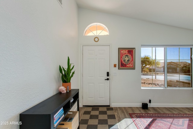 foyer with lofted ceiling and dark hardwood / wood-style flooring