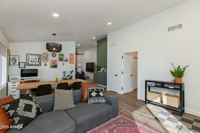 living room featuring high vaulted ceiling and light hardwood / wood-style flooring