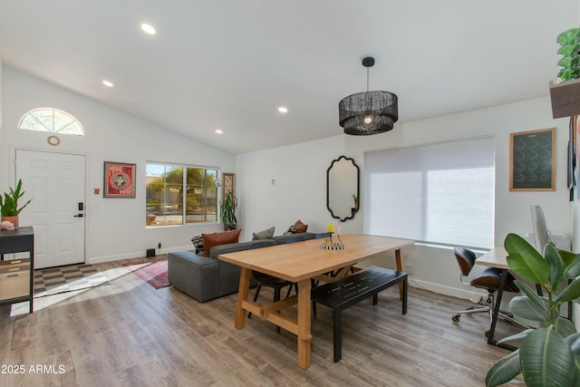 dining room featuring hardwood / wood-style flooring and vaulted ceiling