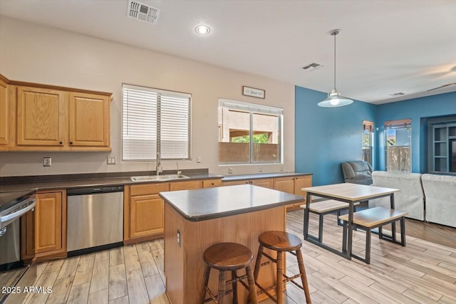 4667 E County Down Dr, Chandler, AZ 85249 - kitchen with stainless steel appliances, light wood-style floors, open floor plan, a center island, and a kitchen breakfast bar