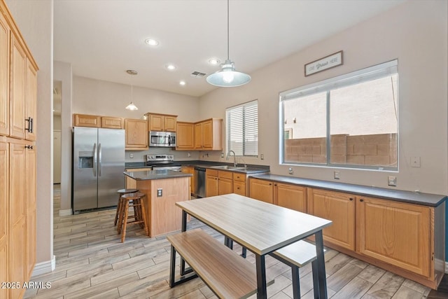 4667 E County Down Dr, Chandler, AZ 85249 - kitchen featuring stainless steel appliances, light wood-type flooring, a center island, dark countertops, and recessed lighting