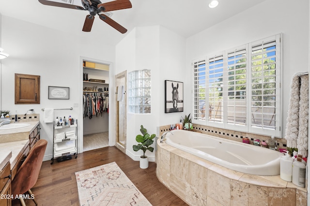 bathroom with wood-type flooring, ceiling fan, separate shower and tub, and vanity