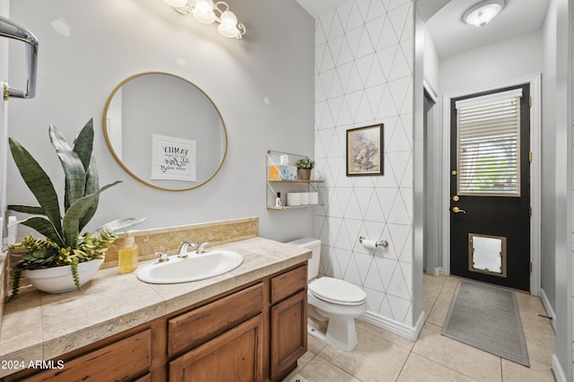 bathroom with vanity, tile patterned flooring, toilet, and tile walls