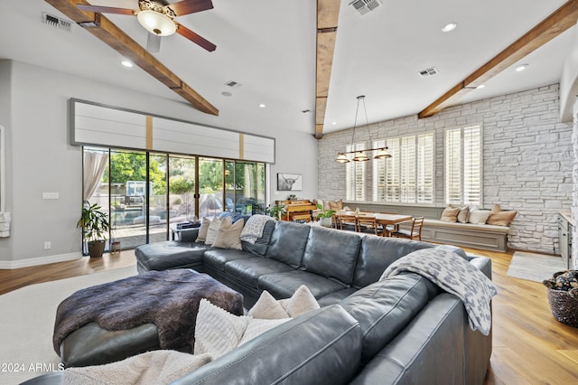 living room featuring ceiling fan with notable chandelier, light hardwood / wood-style flooring, and beam ceiling