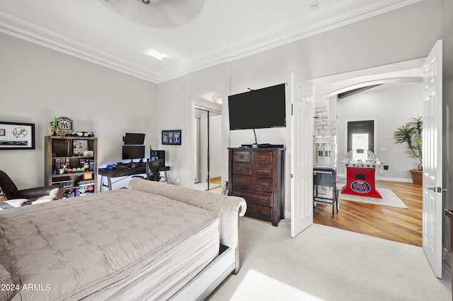 bedroom featuring ornamental molding, light hardwood / wood-style floors, and a closet