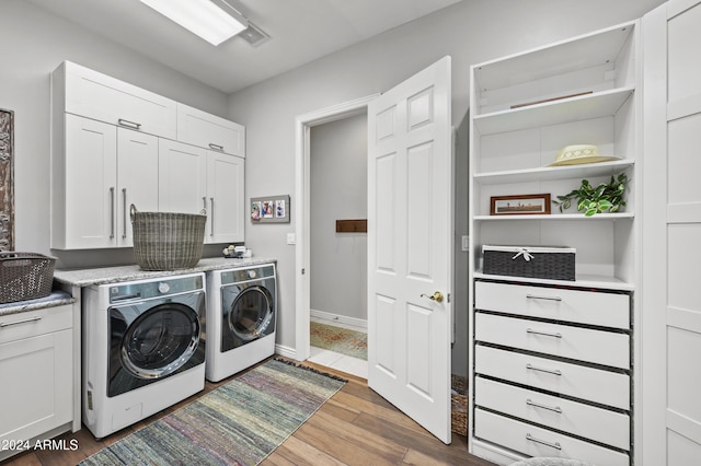 laundry area with dark wood-type flooring, cabinets, and separate washer and dryer