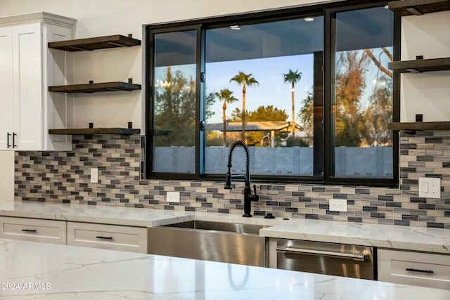 kitchen with dishwasher, light stone countertops, sink, and white cabinets