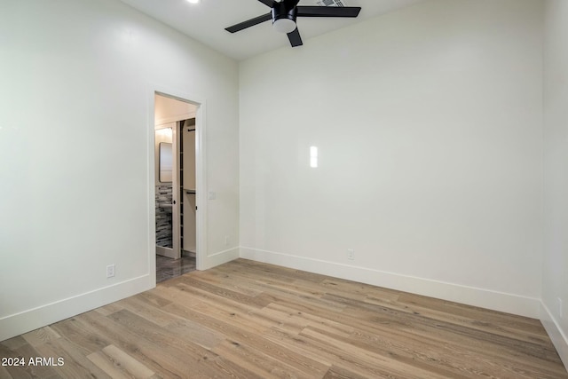 empty room with ceiling fan and light hardwood / wood-style floors