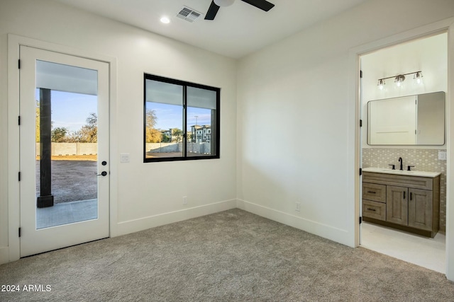 unfurnished bedroom featuring connected bathroom, ceiling fan, sink, access to outside, and light carpet