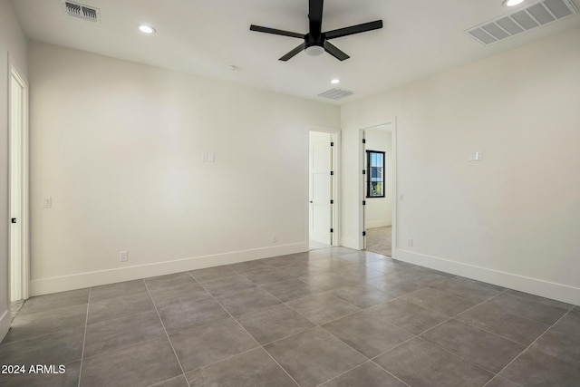 tiled spare room with ceiling fan