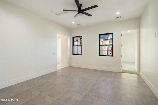 tiled spare room with ceiling fan