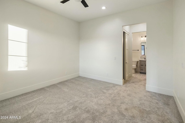 spare room featuring light carpet and ceiling fan