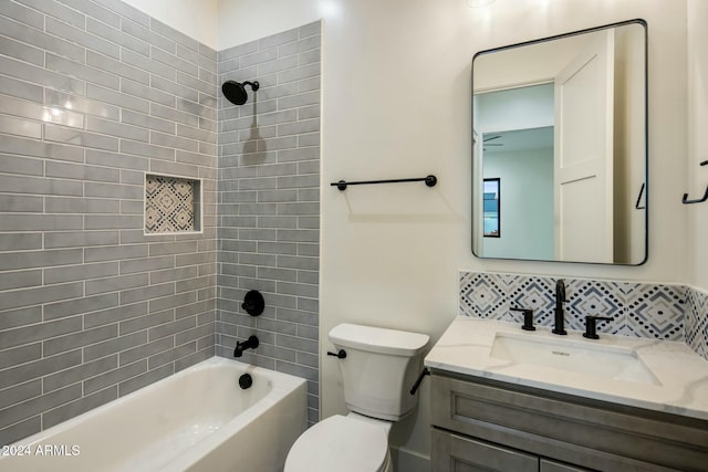 full bathroom with vanity, tasteful backsplash, toilet, and tiled shower / bath