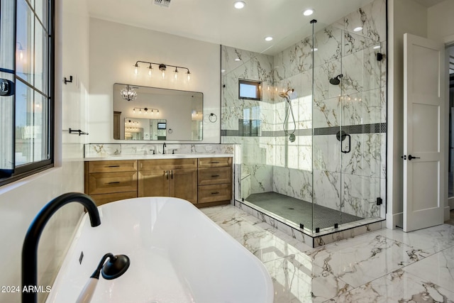 bathroom featuring vanity, a healthy amount of sunlight, and plus walk in shower