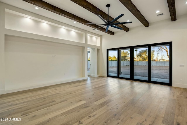 unfurnished living room with beamed ceiling, light hardwood / wood-style floors, and ceiling fan