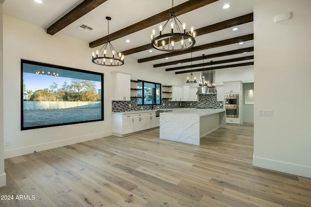 kitchen featuring tasteful backsplash, white cabinetry, beamed ceiling, and pendant lighting