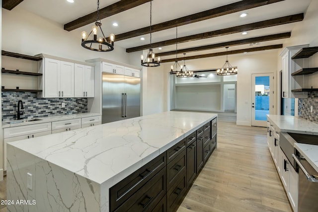 kitchen featuring white cabinets, pendant lighting, stainless steel appliances, and beam ceiling