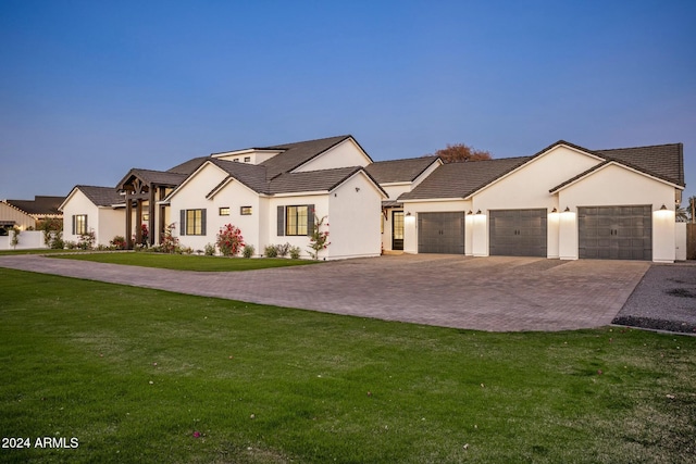 view of front of property with a garage and a yard