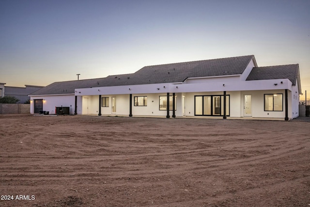 back house at dusk with a patio area