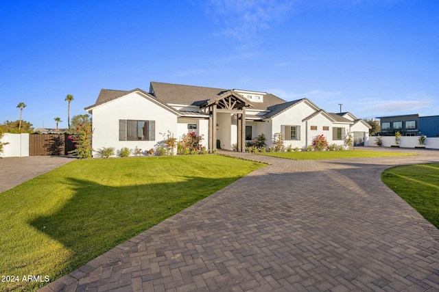 view of front of home featuring a front yard and solar panels