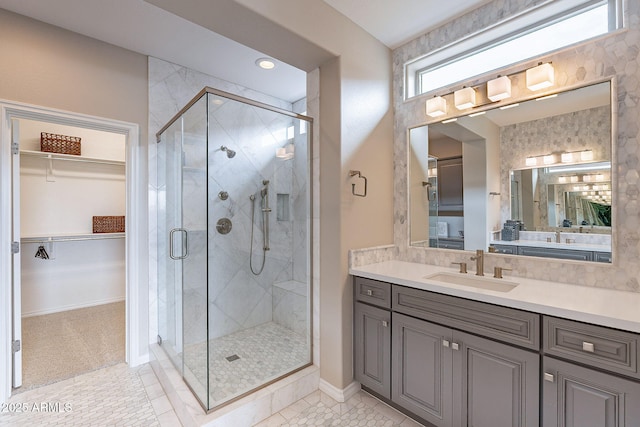 bathroom featuring vanity, a shower stall, a spacious closet, and tile patterned floors