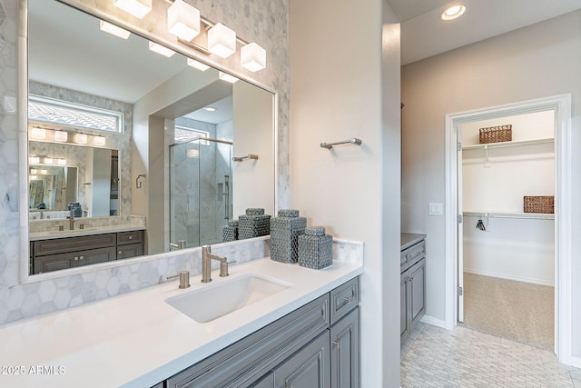 full bathroom featuring a walk in closet, baseboards, recessed lighting, a stall shower, and vanity