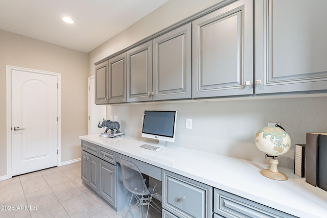 office featuring recessed lighting, baseboards, light tile patterned flooring, and built in desk