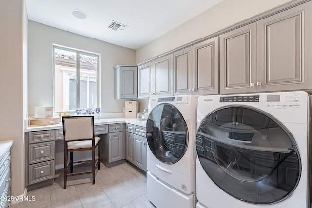 washroom with cabinet space, visible vents, washer and dryer, and light tile patterned floors