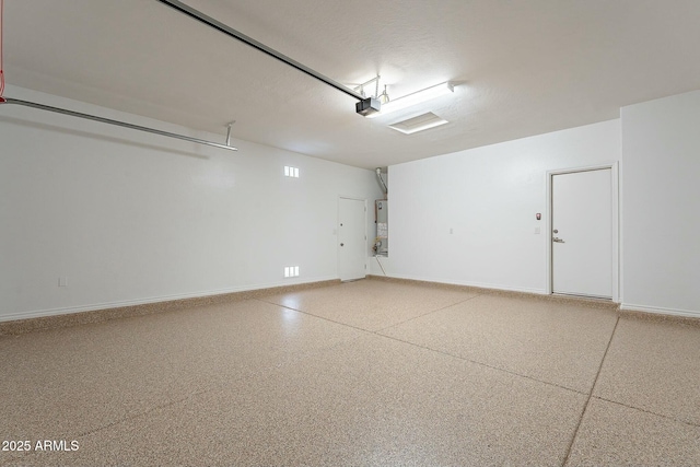 garage featuring gas water heater, baseboards, and a garage door opener