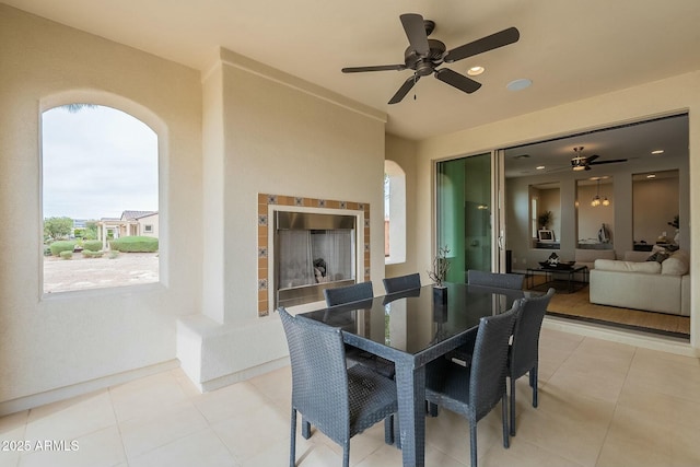 dining area with light tile patterned flooring, arched walkways, and a fireplace