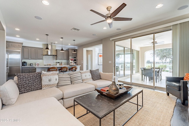 living area with recessed lighting, visible vents, light wood finished floors, and ceiling fan