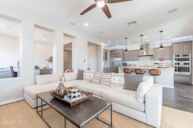 living room featuring a ceiling fan, wood finished floors, visible vents, baseboards, and recessed lighting