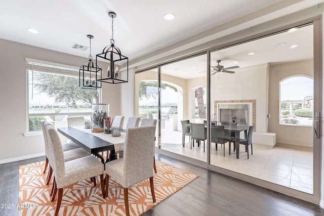 dining room with visible vents, arched walkways, plenty of natural light, and wood finished floors