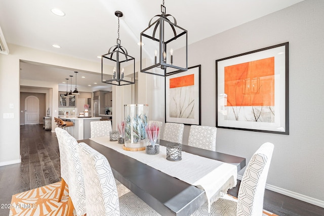 dining room with dark wood finished floors, recessed lighting, arched walkways, and baseboards