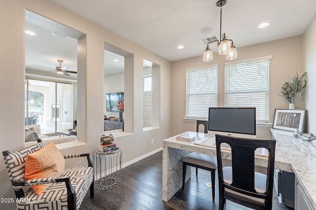 home office with dark wood finished floors, a healthy amount of sunlight, visible vents, and baseboards