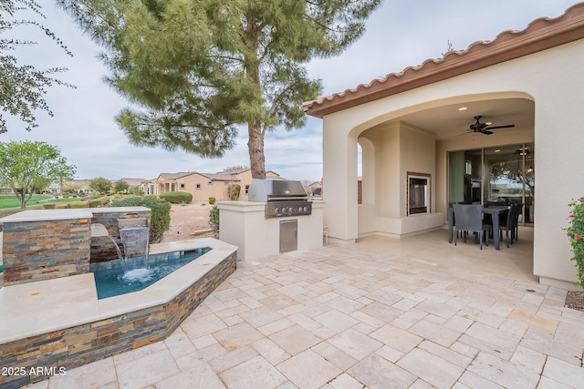 view of patio / terrace with an outdoor kitchen, outdoor dining area, a ceiling fan, and grilling area