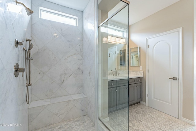 full bath with a marble finish shower and vanity