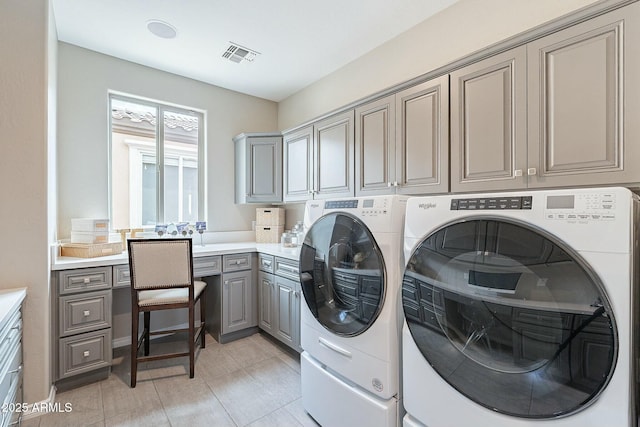 laundry area featuring visible vents, cabinet space, light tile patterned flooring, and washer and clothes dryer