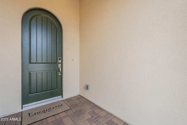 view of exterior entry featuring stucco siding