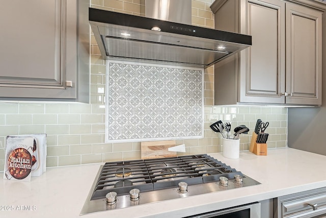 kitchen with stainless steel gas cooktop, tasteful backsplash, light countertops, and extractor fan