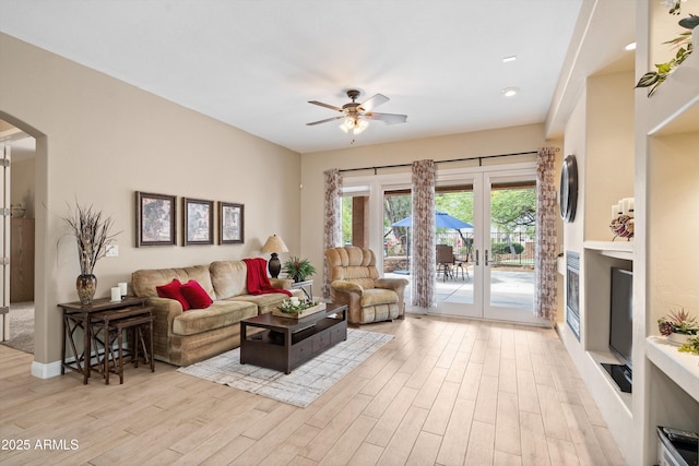 2221 W Calle De Las Estrella Way, Phoenix, AZ 85085 - living area with arched walkways, light wood-style flooring, a ceiling fan, and french doors