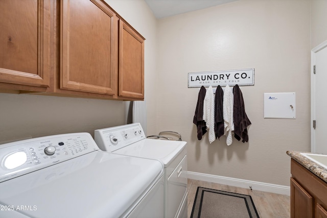 2221 W Calle De Las Estrella Way, Phoenix, AZ 85085 - washroom with washer and clothes dryer, cabinet space, and light wood-style flooring