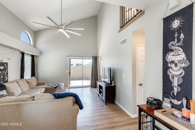 living area featuring visible vents, baseboards, high vaulted ceiling, a ceiling fan, and light wood-style flooring