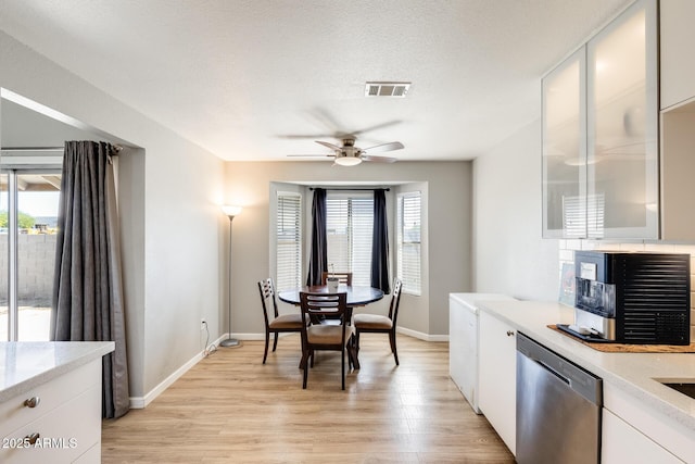 dining space with a ceiling fan, baseboards, visible vents, and light wood-style flooring