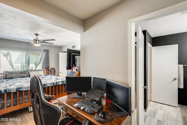 office space featuring a textured wall and a ceiling fan