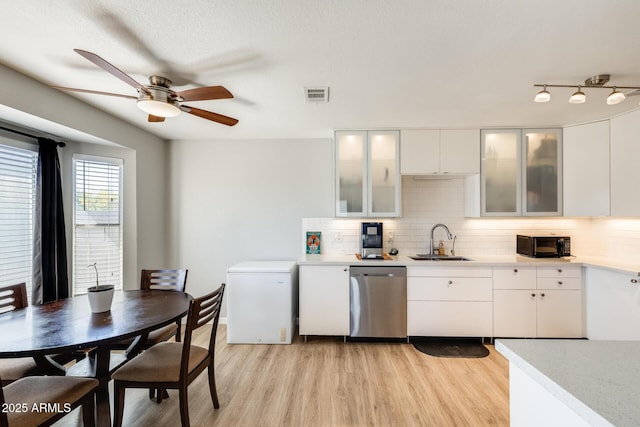 kitchen with visible vents, a sink, light wood finished floors, and dishwasher