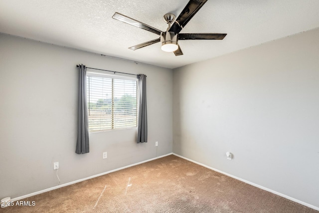 spare room with baseboards, a ceiling fan, carpet flooring, and a textured ceiling