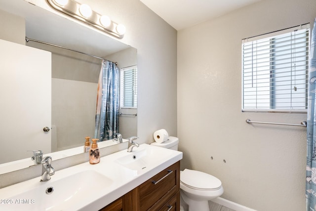 bathroom featuring double vanity, toilet, a shower with shower curtain, and a sink