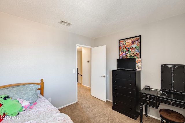 carpeted bedroom with baseboards, a textured ceiling, and visible vents